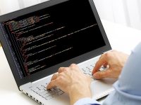 49121562 - programmer profession - man writing programming code on laptop computer